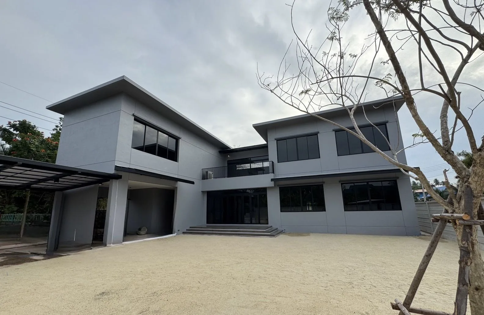 บ้านพักอาศัย สมุทรสงคราม — ภายนอกบ้านสองชั้นโทนเทา มุมกลางวัน